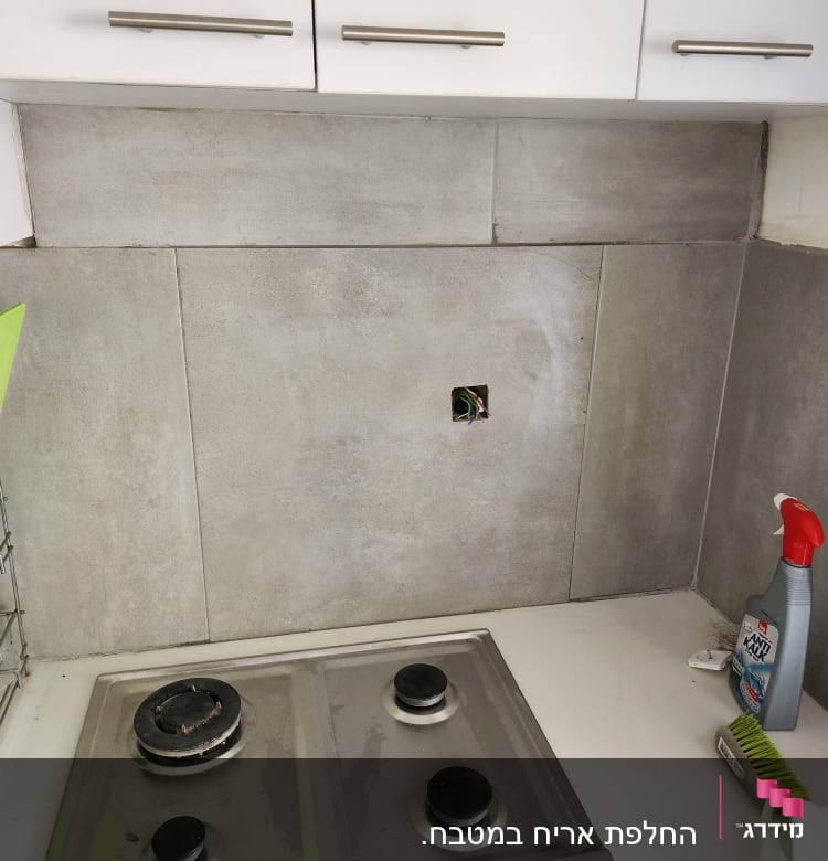 כיריים עם אריחים חדשים וחור בקיר